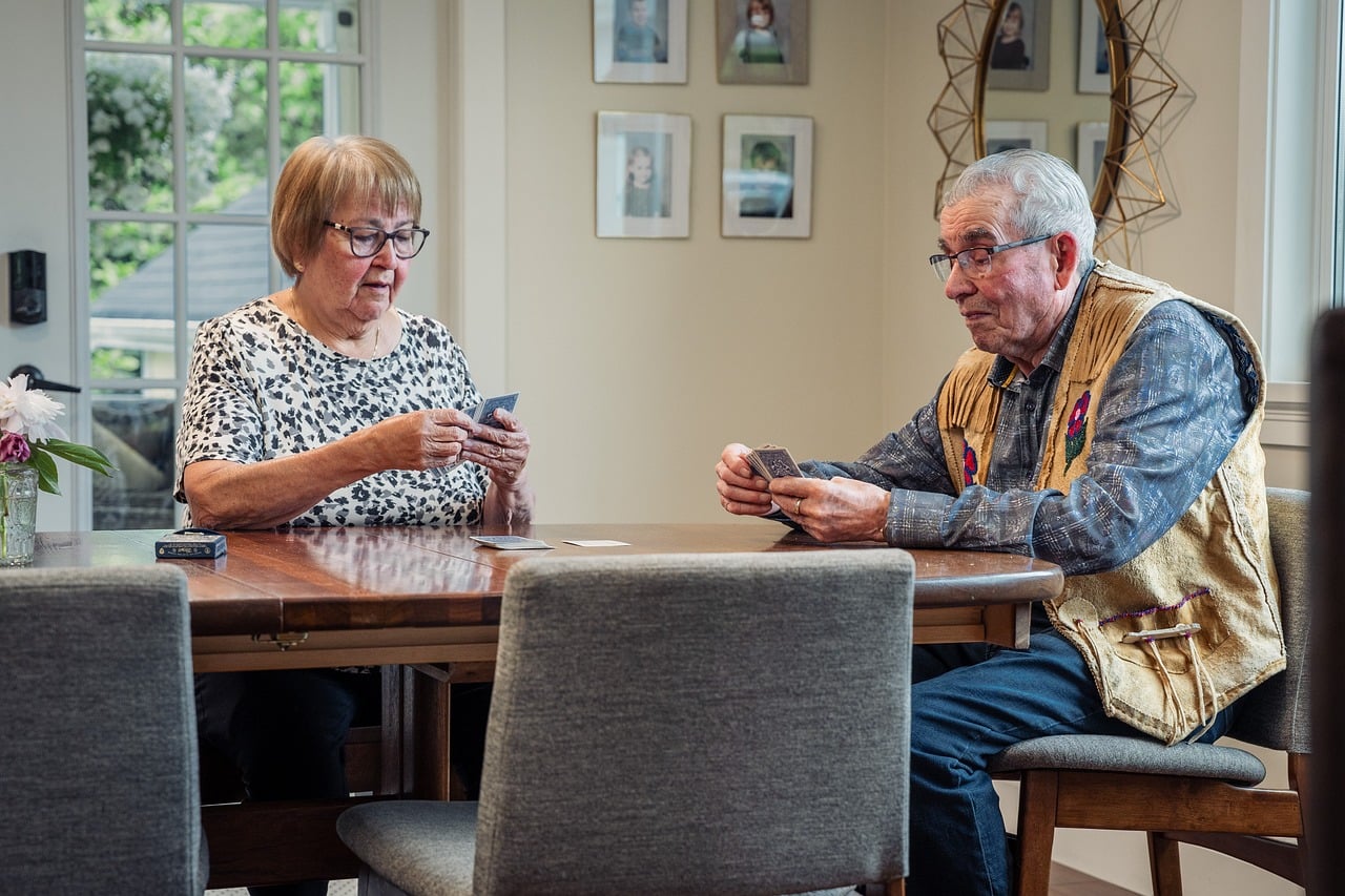 Card game, elderly couple, indoors — Online slot games- What are your best bets?